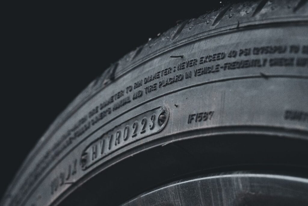 Detailed close-up image of a black car tire showcasing sidewall text and treads.