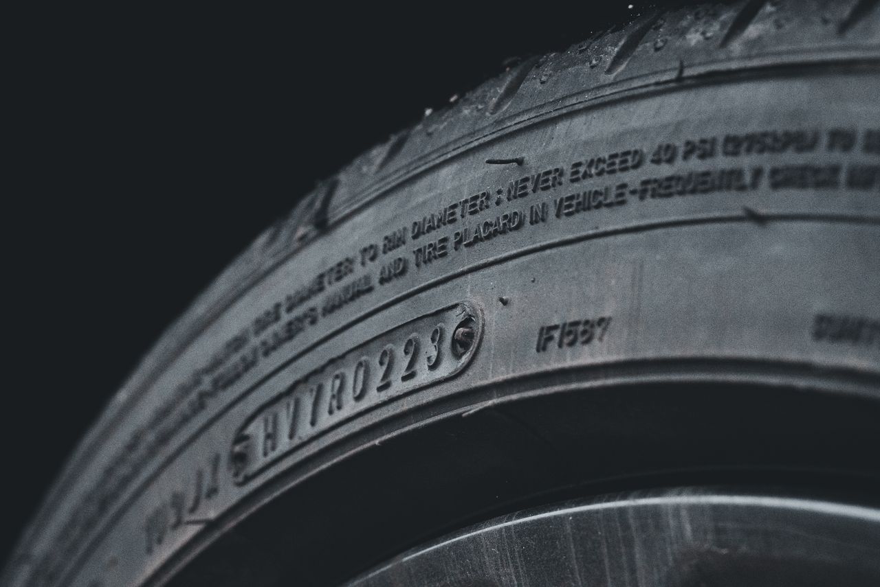 Home Detailed close-up image of a black car tire showcasing sidewall text and treads.